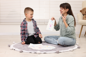 Parent working with child on autism therapy activities at home using visual supports and play-based techniques